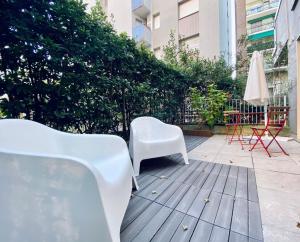 圣多纳托-米拉内塞NEW - Nuovo appartamento in centro的坐在庭院里的两把白色椅子