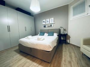 圣多纳托-米拉内塞NEW - Nuovo appartamento in centro的一间卧室配有一张带白色床单和蓝色枕头的大床。