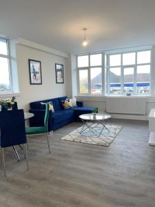 弗特威克Flitwick Luxury Apartments的客厅配有蓝色的沙发和桌子
