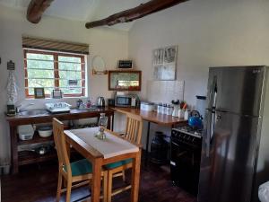 奥茨胡恩Aloe Valley Retreat的厨房配有不锈钢冰箱和桌子