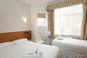 伦敦Anchor Guest House的酒店客房设有两张床和窗户。