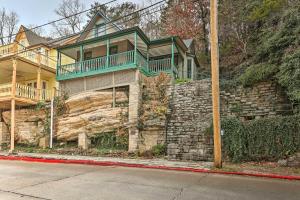 尤里卡斯普林斯Cozy Eureka Springs Cottage, Walk to Dtwn!的一座大房子,在石墙上设有绿色阳台