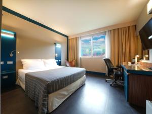 佩鲁贾拉梅利笛安娜酒店的配有一张床、一张书桌和一扇窗户的酒店客房