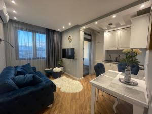 巴尔XIO Apartments的客厅配有蓝色的沙发和桌子