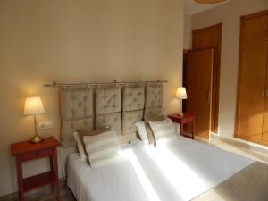 塞维利亚塞维利亚阿雷纳尔旅馆的一间卧室配有一张带两盏灯的大型白色床。