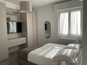 佩罗Domus Pyrus Apartments的一间白色卧室,配有床和电视
