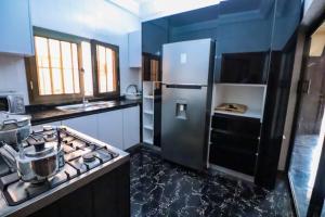 洛美Villa Nika的厨房配有不锈钢冰箱和炉灶。