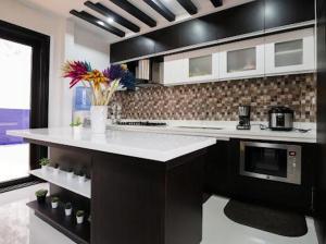 大雅台tagaytay transient ph的厨房配有白色的柜台和微波炉