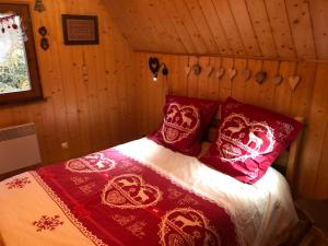维尔德巴赫Chalet Le Cerf的一张床上,床上有红白的毯子和枕头
