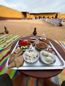 阿斯旺Arafa Nubian Guest house的桌上的食品托盘,上面有食物