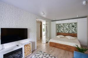 阿拉木图апартаменты Djent-house的卧室配有1张床和1台砖墙电视