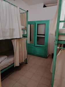 瓦尔卡拉Molly's Hostel的一间设有双层床和绿门的客房