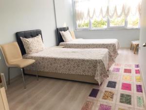 埃德雷米特Altınkum Sahil'de bahçeli nezih yazlık的一间卧室设有两张床、一把椅子和一个窗户。