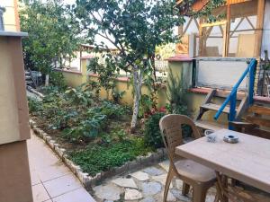 埃德雷米特Altınkum Sahil'de bahçeli nezih yazlık的一个带桌椅的庭院和一个花园