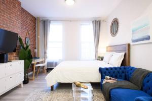 纽约240-5 NEW Prime Location STUDIO W&D in unit的一间卧室配有一张床和一张蓝色的沙发