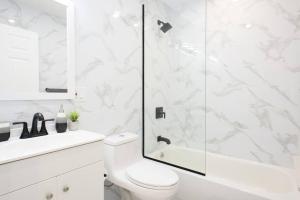 纽约240-5 NEW Prime Location STUDIO W&D in unit的带淋浴和卫生间的白色浴室