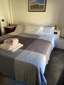 RoppoloLocanda Tarello1880的一间卧室配有一张大床和毛巾