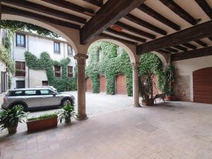 曼托瓦Corte Pomponazza的一座庭院,在一座建筑前设有停车位