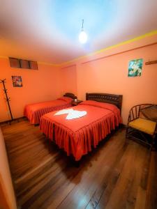 科帕卡巴纳HOSTAL Luz YHOBIMAR的一间卧室配有两张红色床单