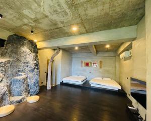 盐寮清和山房民宿的带石墙的客房内的两张床