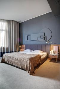 敖德萨诗人艺术酒店的一间卧室设有一张大床和蓝色的墙壁