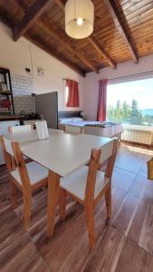 圣卡洛斯-德巴里洛切Astrolabio Hostel的一间配备有白色桌椅的用餐室