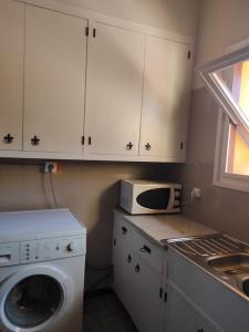 马塔罗Apartamentos Can bruguera 2的厨房配有洗衣机和微波炉。