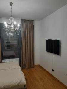 VoždivacApartman Marija的一间卧室配有一张床和一个吊灯