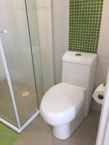 瓜鲁雅Flat Capitania Varam的一间带卫生间和玻璃淋浴间的浴室