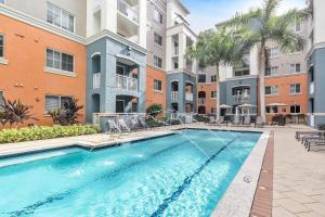 迈阿密Dharma Home Suites South Miami at Red Road Commons的一座公寓大楼内的游泳池,大楼内有一座建筑