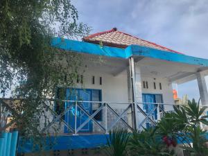吉利特拉旺安The House Hostel的白色和蓝色的房子,设有蓝色的门