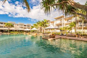 金斯克里福Peppers Plunge Pool Perfection 2br spa suite的棕榈树和建筑度假村的游泳池