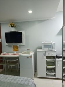 卡波布里奥** SUITE PRIVATIVA PRAIA DO FORTE CABO FRIO **的厨房配有冰箱和带微波炉的桌子。