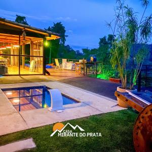 彼得罗波利斯Casa Mirante do Prata no Vale das Videiras的夜间带游泳池的别墅