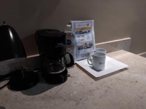 韦拉克鲁斯EXECUTIROOMS VERACRUZ的咖啡壶和柜台上的杯子