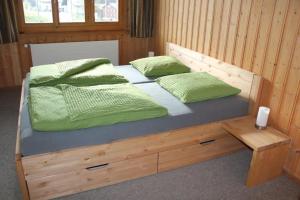 塞德龙格萨提尼公寓的一张带两个绿色枕头的木床