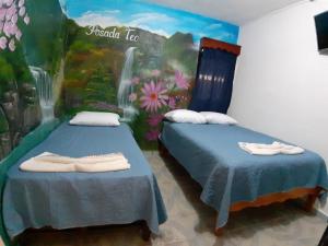 希利特拉Posada TEO的墙上画画的房间里设有两张床