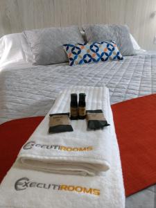 韦拉克鲁斯EXECUTIROOMS VERACRUZ的一张带毛巾的床和两瓶便服