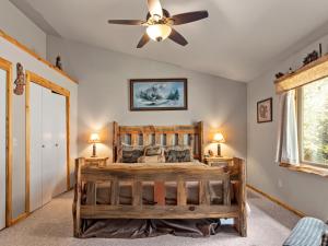 埃斯蒂斯帕克松树天堂度假村的一间卧室配有一张木床和吊扇