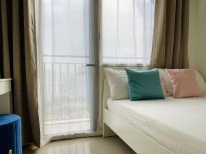 马尼拉Sakan 5-Star Quality Condotel的靠窗前的带枕头的床