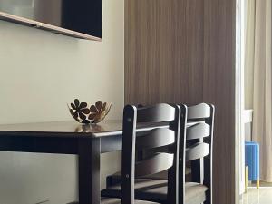 马尼拉Sakan 5-Star Quality Condotel的一间带桌子和两把椅子的用餐室