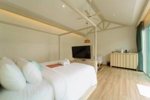 奥南海滩The Pin Boutique Pool Villa Krabi的卧室配有白色的床和平面电视。