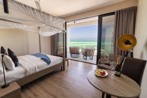 江比阿Villa Bluu的酒店客房设有一张床铺、一张桌子和一间用餐室。