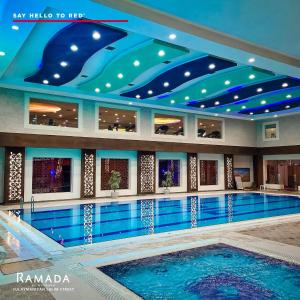 苏莱曼尼亚Ramada by Wyndham - Sulaymaniyah Salim Street的蓝色天花板的酒店游泳池