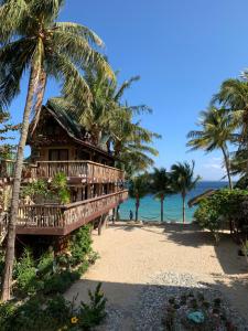 波尔多·格尼拉Bamboo House Beach Lodge & Restaurant的棕榈树和海洋海滩上的度假村