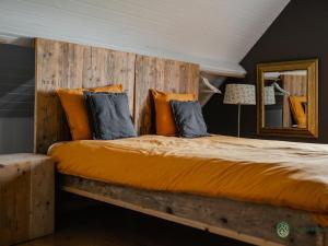 伦德Authentic Holiday Home in North Brabant by the Forest的一间卧室配有一张大床和木制床头板