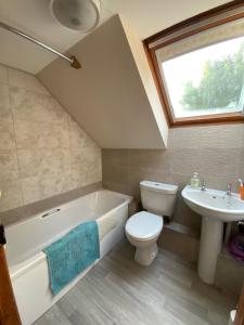 切尔滕纳姆Sherbourne Cottage, Seven Springs Cottages的浴室配有白色浴缸、卫生间和水槽。