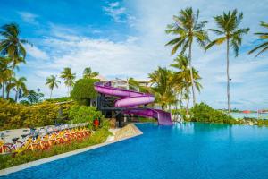 南马累环礁Hard Rock Hotel Maldives的一个带游泳池的度假村的紫色水滑梯