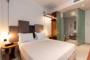 海若克利欧DOM Boutique Hotel的一间带白色大床的卧室和一间浴室