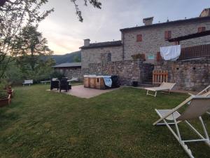 菲乌马尔博阿尔卑斯萨拉农家乐的一个带椅子的院子和石头建筑